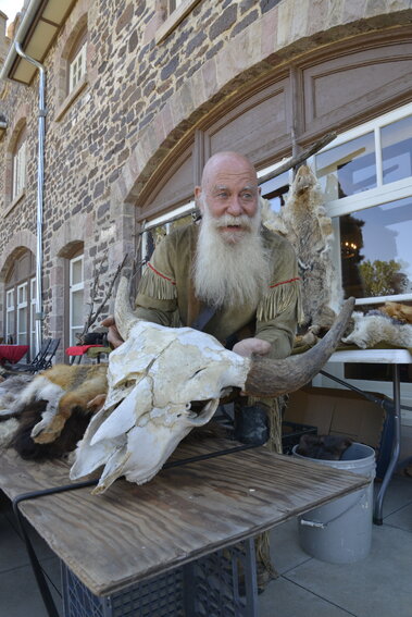 Trapper Johnny holds up can animal skull at his station in front of the Highlands Ranch Mansion. He spoke to families about the trapping and showed them a variety of items.